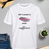 Bijela majica s natpisom *"All I need is mascara and caffeine"*, gdje je riječ "mascara" istaknuta ružičastim fontom, dok su ostale riječi u crnoj boji. Dizajn uključuje crne linije koje simboliziraju poteze maskare. Majica je položena na ravnu površinu uz slameni šešir s crnom vrpcom, svijeću, zelenu biljku u tegli, otvorenu knjigu i traperice.